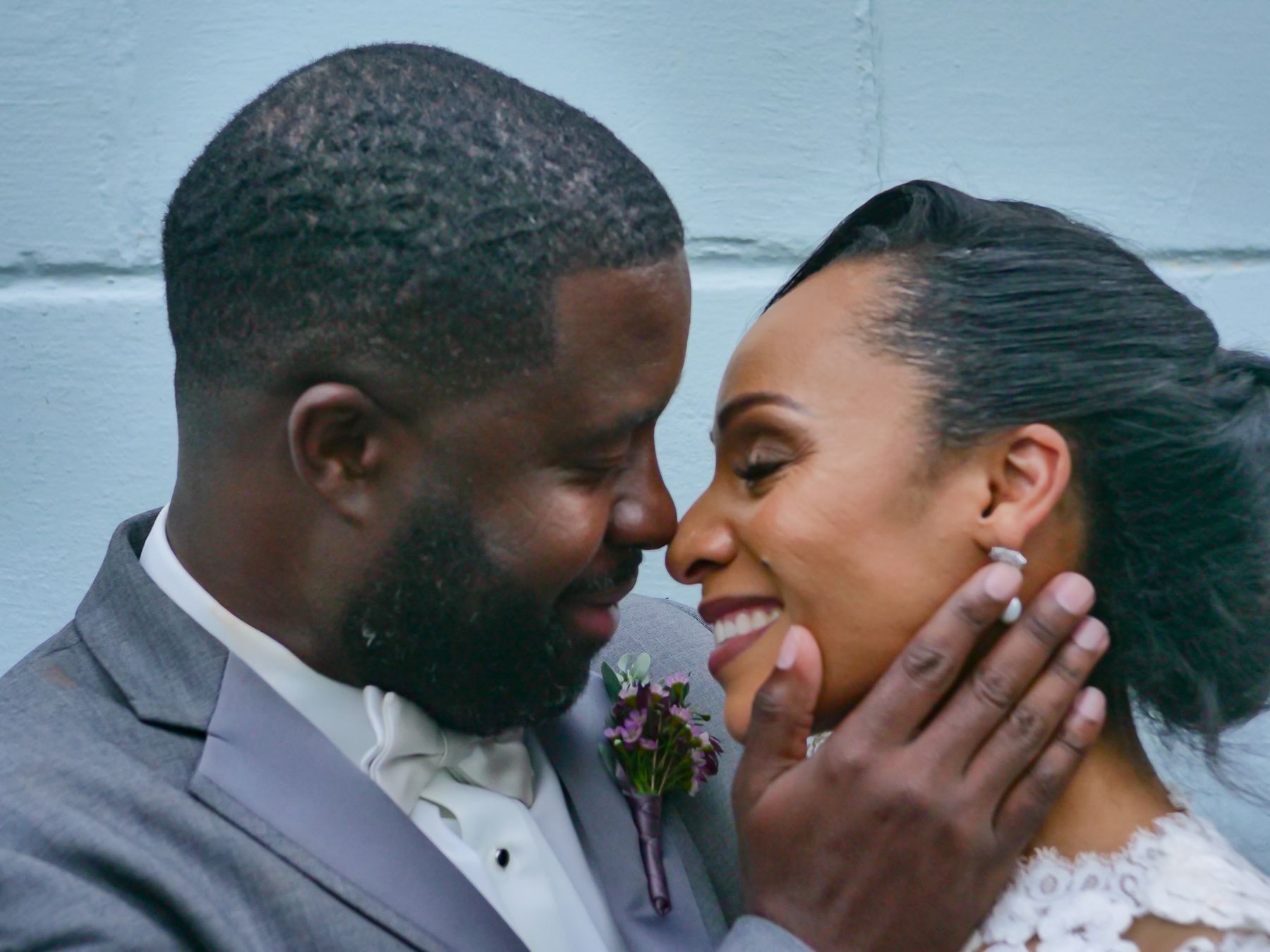 Groom's hand on the bride's cheek, both smiling