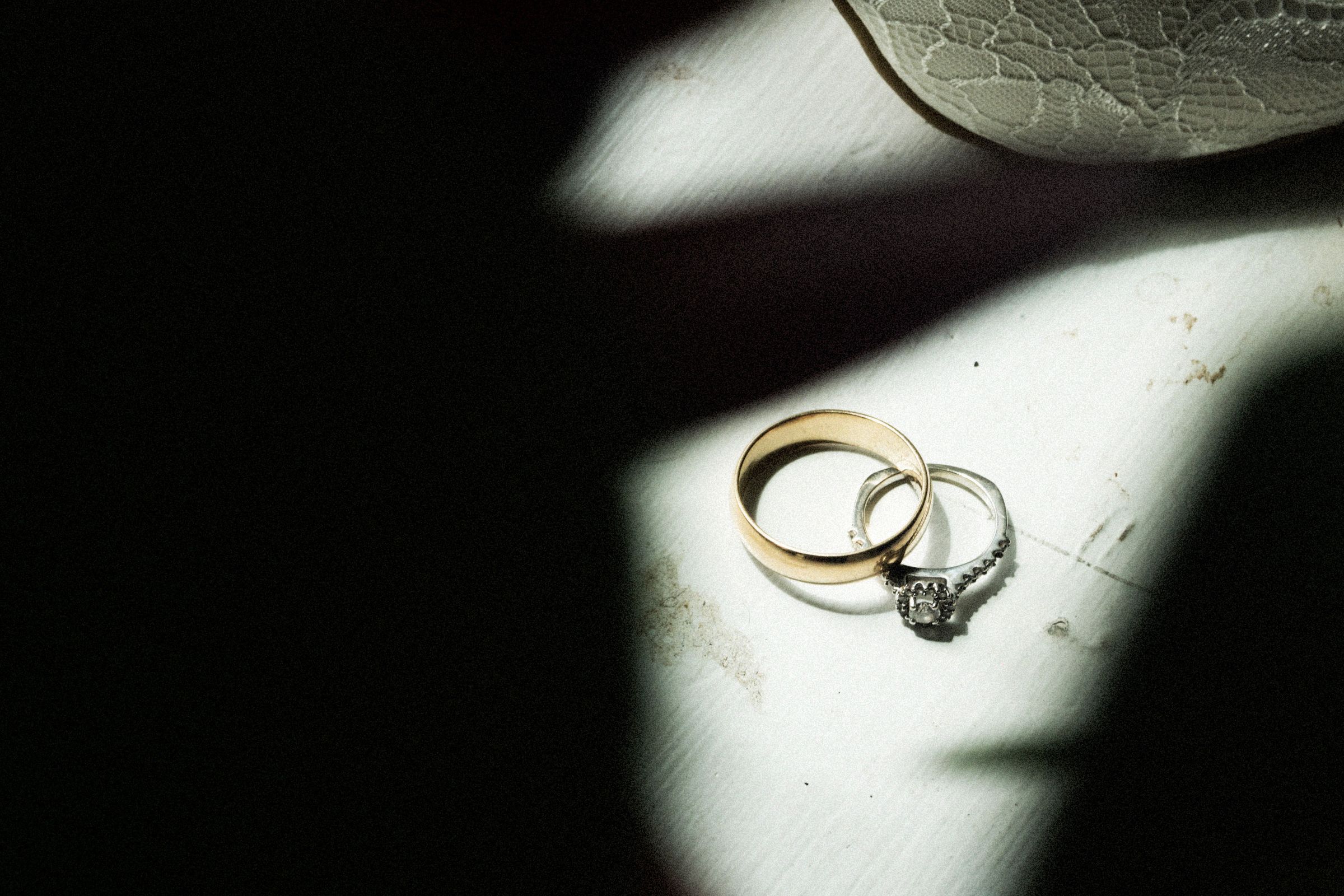 Wedding rings resting in a slice of light